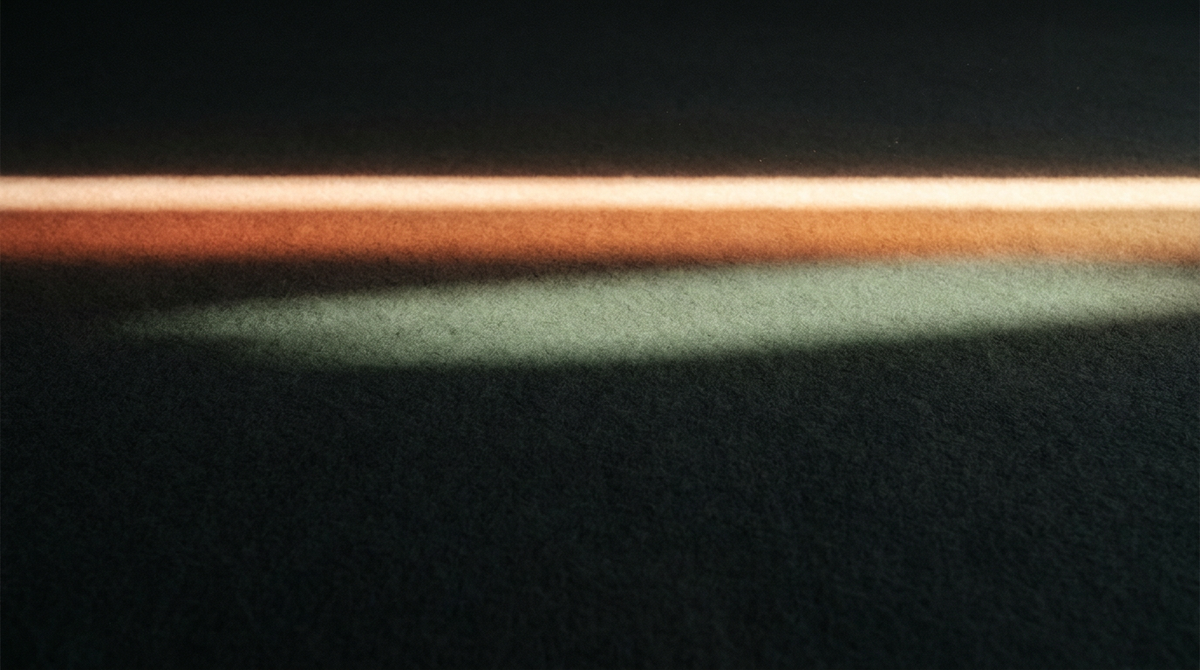 Single bold luminous horizontal line breaking through dark charcoal field — visual metaphor for the initiating, breakthrough energy of a Manifestor
