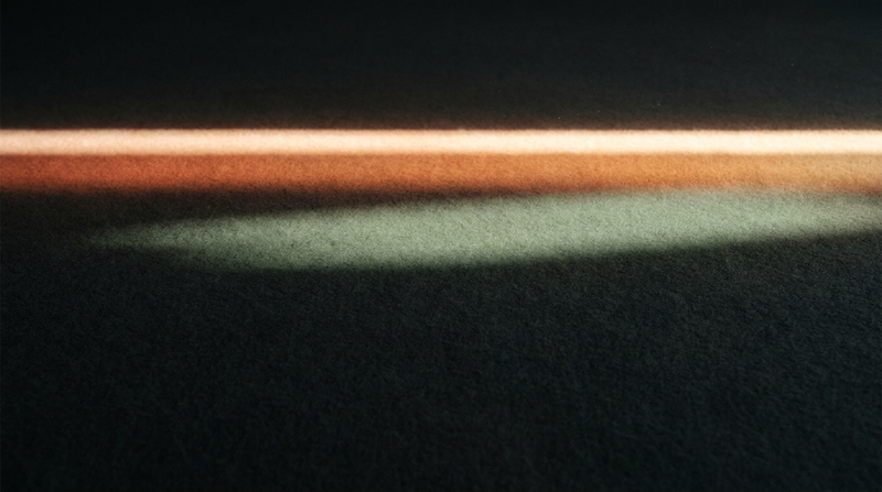 Single bold luminous horizontal line breaking through dark charcoal field — visual metaphor for the initiating, breakthrough energy of a Manifestor